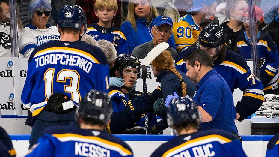 Blues player hit in neck with puck, keeps playing before eventually being stretchered off