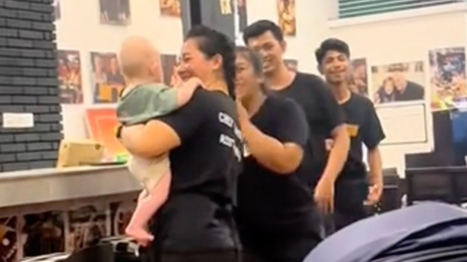 Restaurant staff watch baby so parents can eat meals in peace